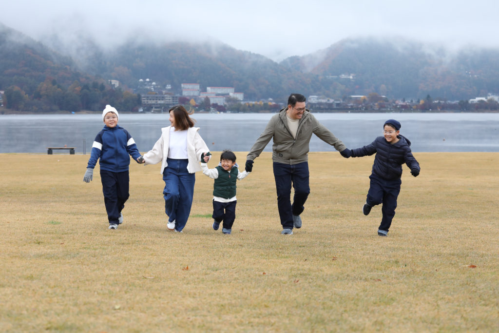 042 Three brothers running in an empty lakeside park after the rain