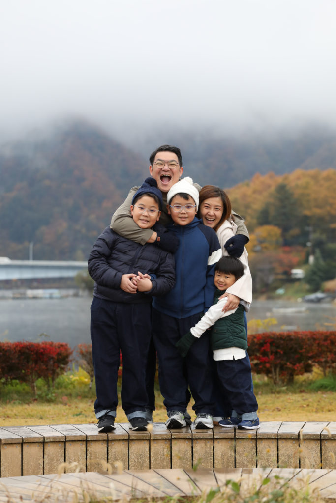 068 Parents and three boys shouting with autumn leaves and misty background